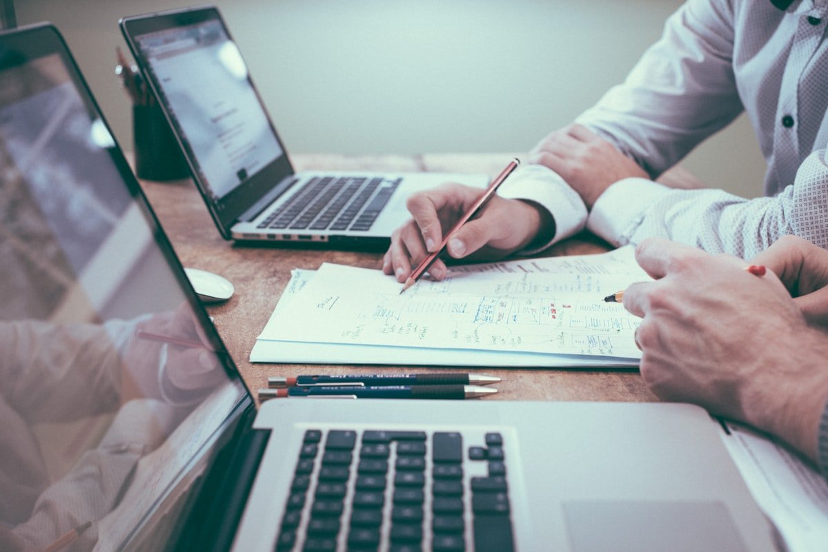Deux professionnels travaillant ensemble sur une stratégie marketing avec documents et laptop